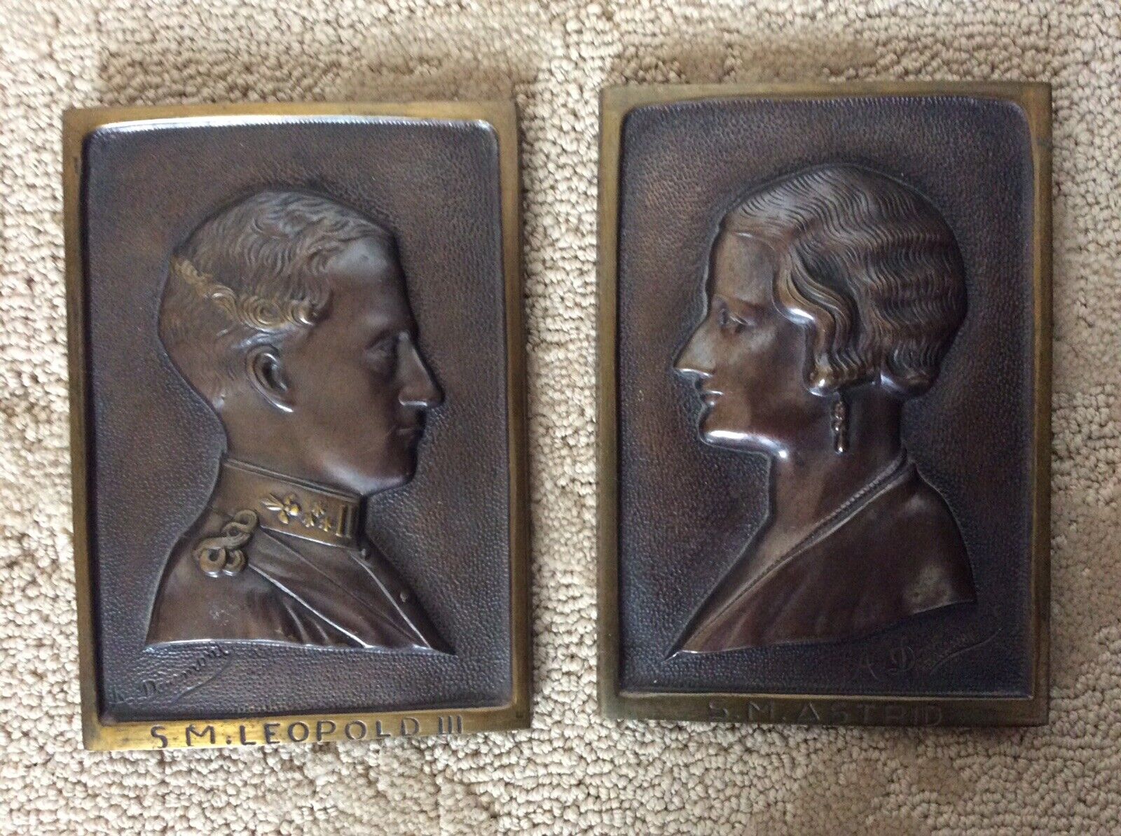 A PAIR OF BRONZE PLAQUES KING AND QUEEN OF BELGIUM SIGNED BY ARTIST A DAUMONT