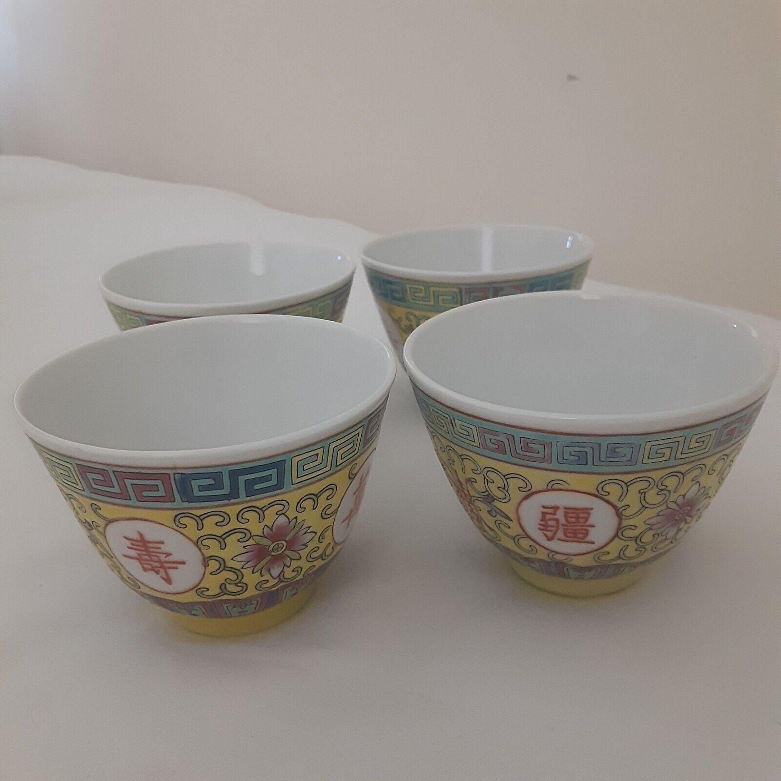 Four vintage Chinese longevity tea cups with greek key border.
