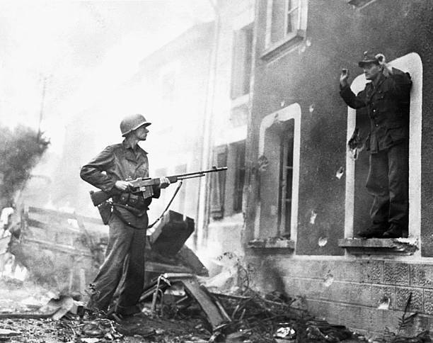 American soldier aims rifle captured German soldier emerging war-da- Old Photo