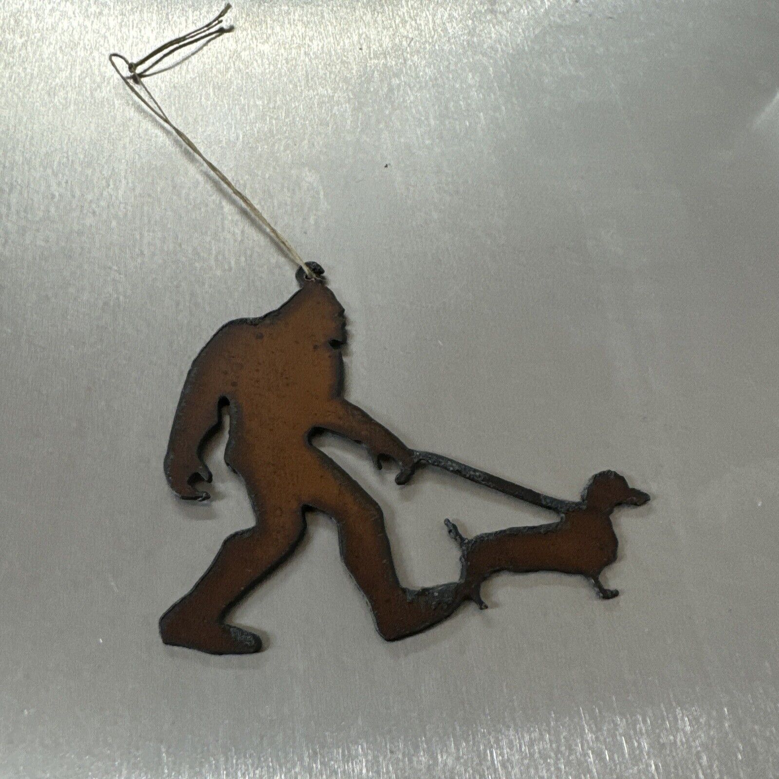Bigfoot walking dachshund Christmas ornament metal