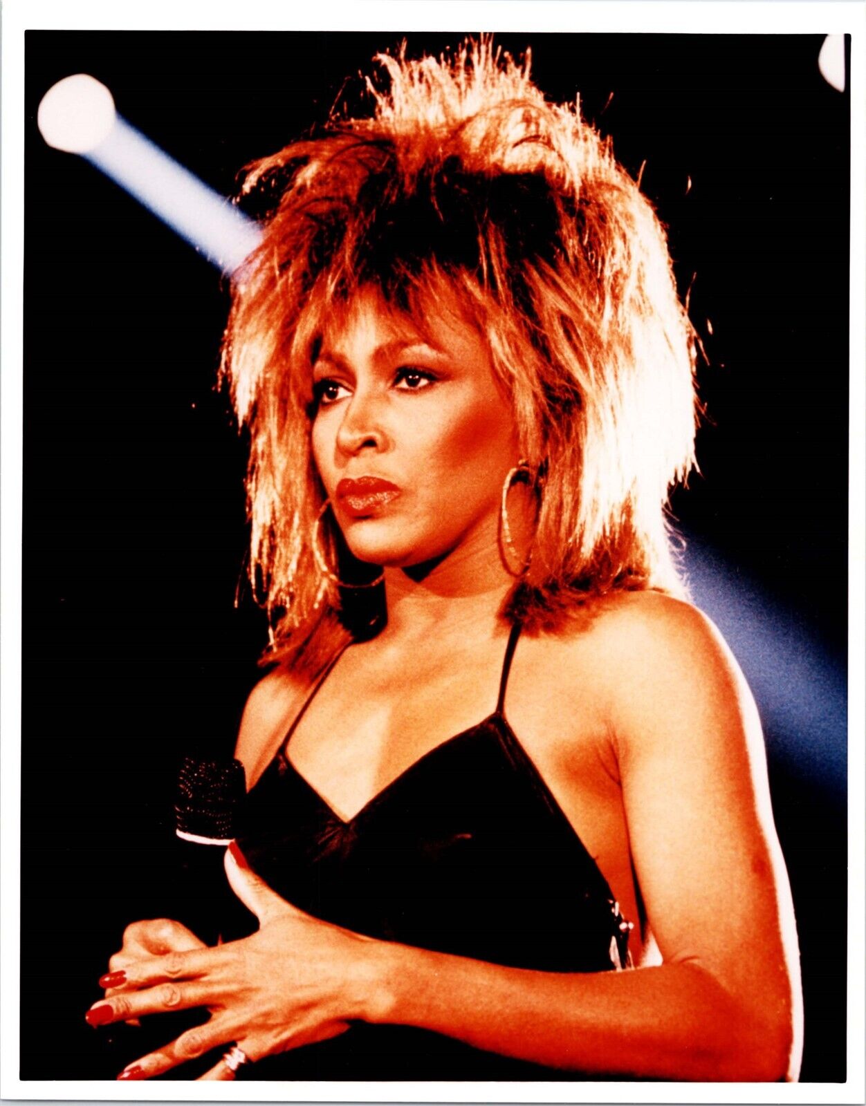 Tina Turner vintage 1980's 8x10 inch press photo holding microphone in concert