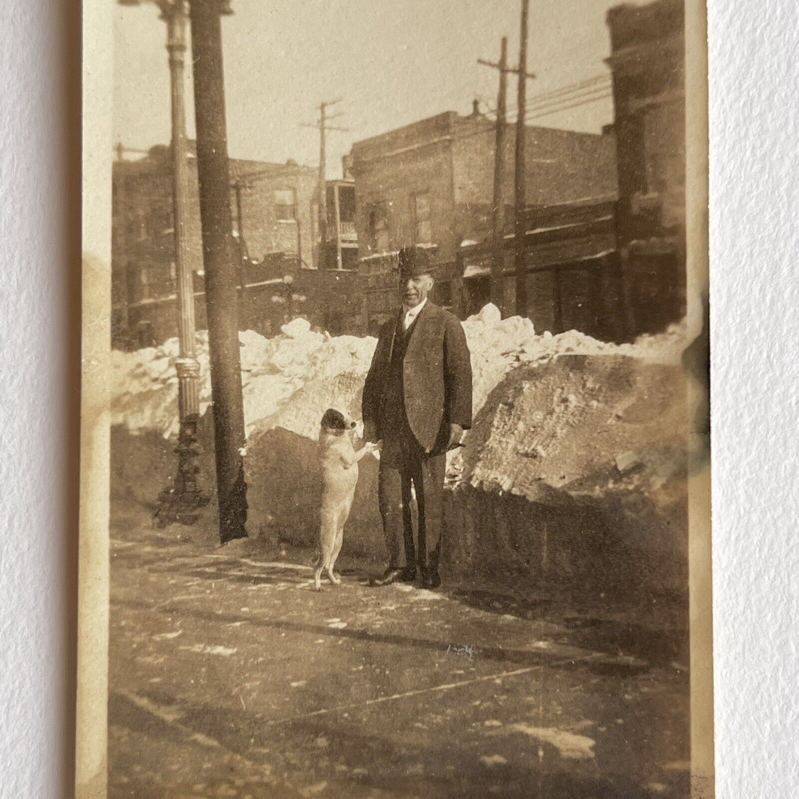 Antique Sepia Snapshot Photograph Man On Street With Dog Doing Trick Snow Odd