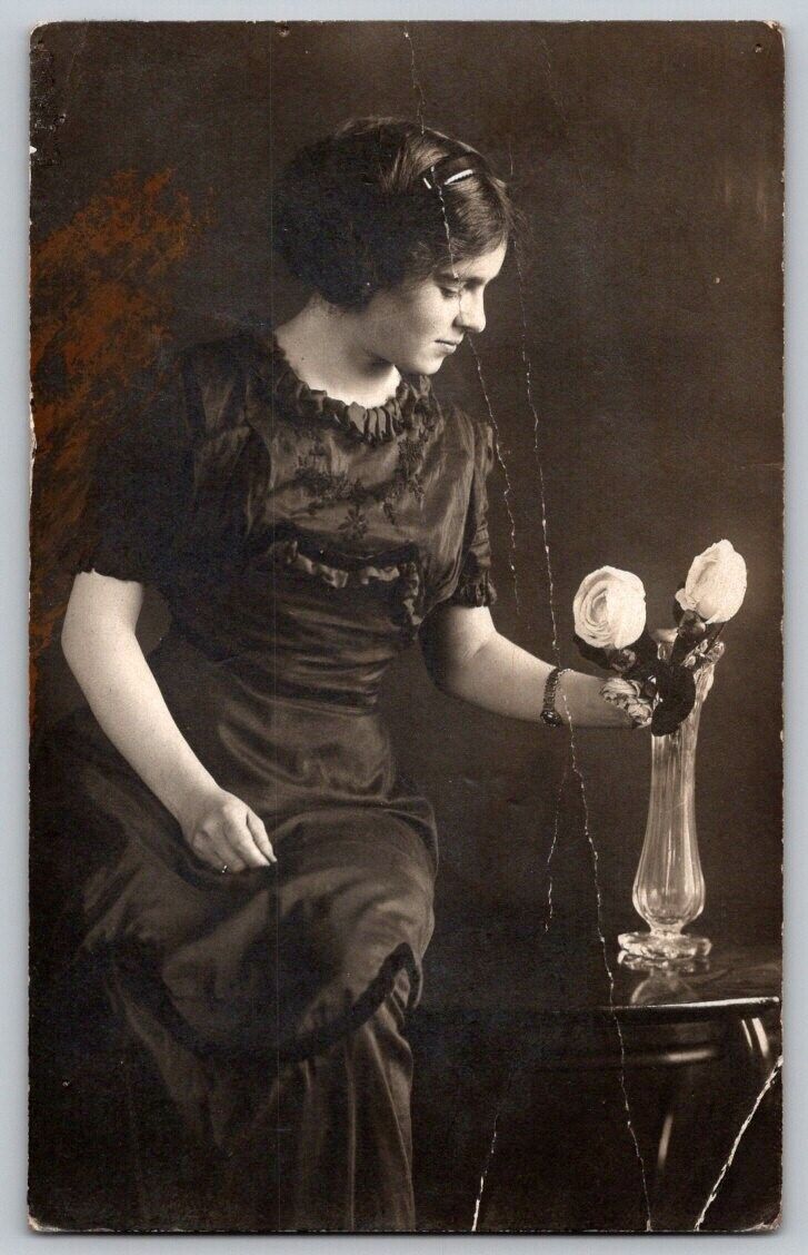 vintage portrait woman arranging roses in vase RPPC Postcard DAMAGED