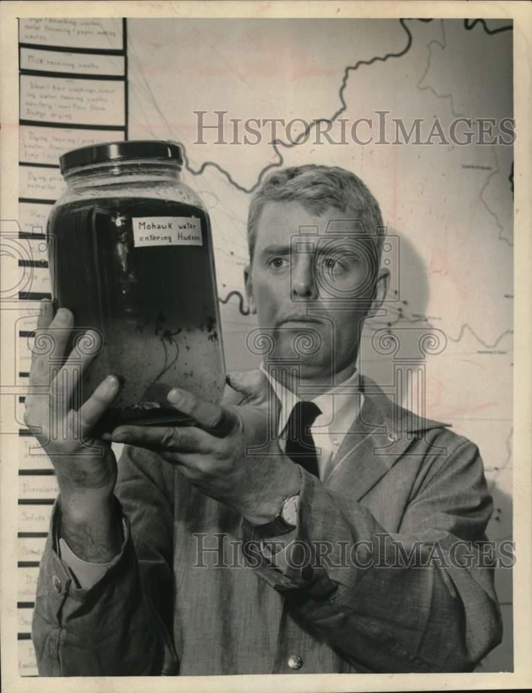 1966 Press Photo Todd Pulliam examines jar of water from Mohawk River, New York