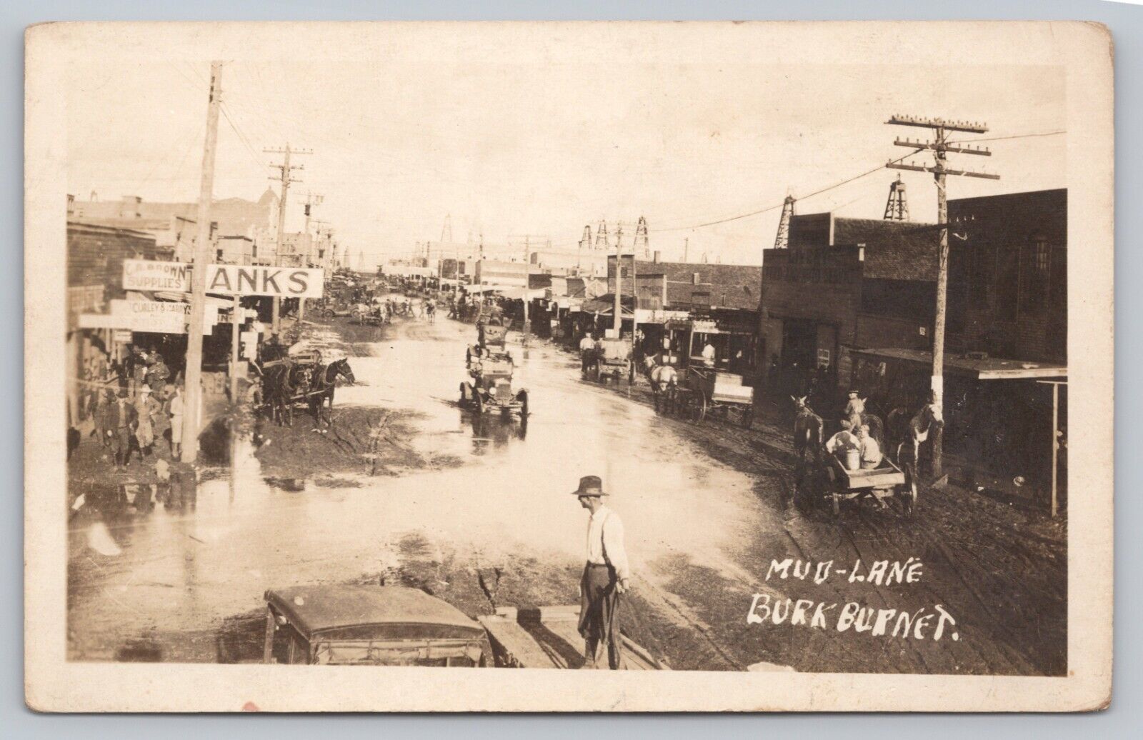 Postcard TX RPPC Burkburnett Mud Lane Flooding Dirt Rd Stores Signs Oil Town I9