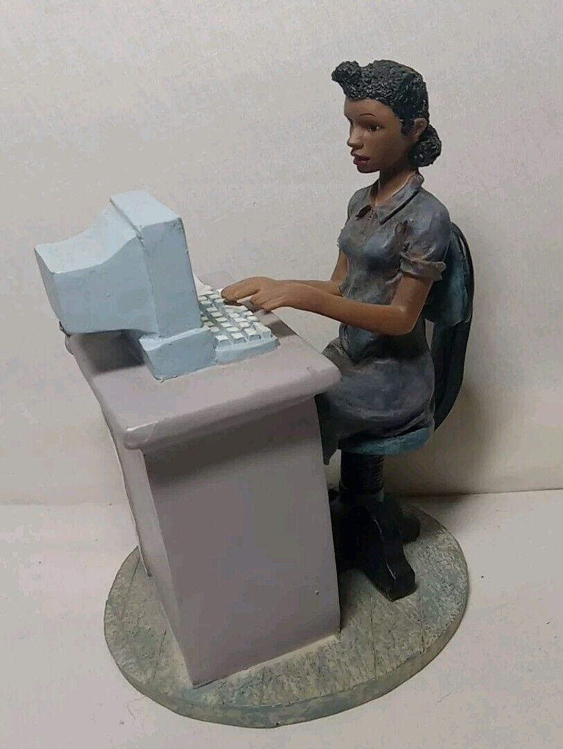 Woman Sitting At Desk With Computer Figurine