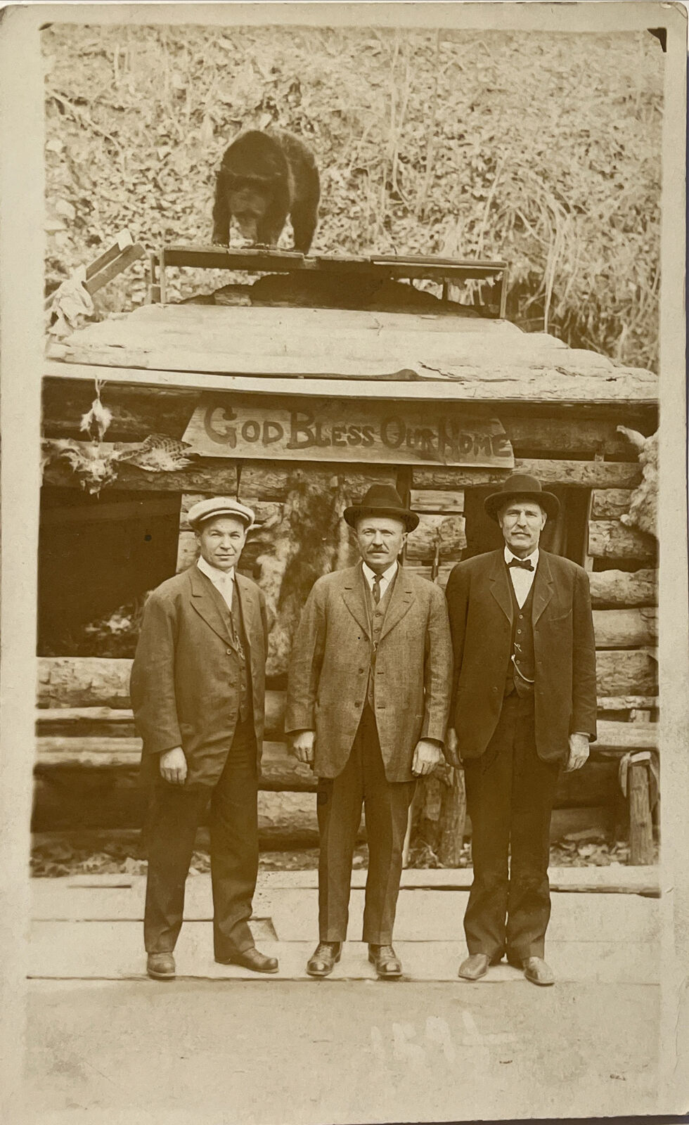 RPPC Postcard Men Posing In Front Of Log Home W Bear On Top Portrait God Bless