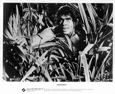 An unknown actor a Neanderthal looking through deep jungle plants - Old Photo picture