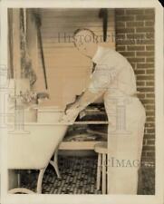 Press Photo Comedic actor Ben Turpin scrubs laundry on a washboard at home picture