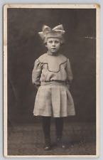 RPPC Little Girl With Big Hair Bow Standing In Studio c1910  Real Photo Postcard picture