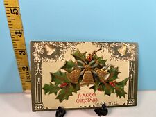 1907 A Merry Christmas embossed Gold Bells cascaded in Green Holly Postcard. picture