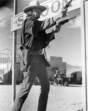 Clint Eastwood as Josey Wales in town by saloon firing two pistols 8x10 photo picture